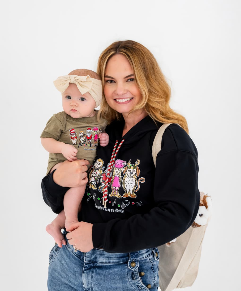 Mom wearing black cropped Friends hoodie, holding baby in natural Friends onesie – part of our mommy and me gifts collection.